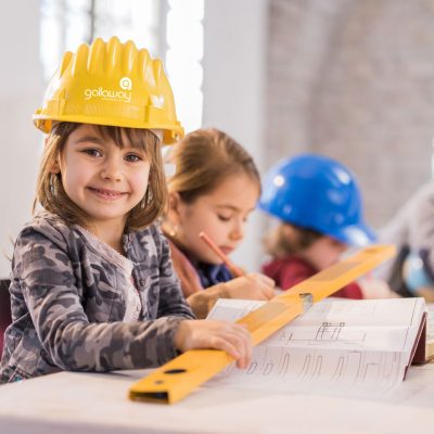 Young girl with hard hat and spirit level